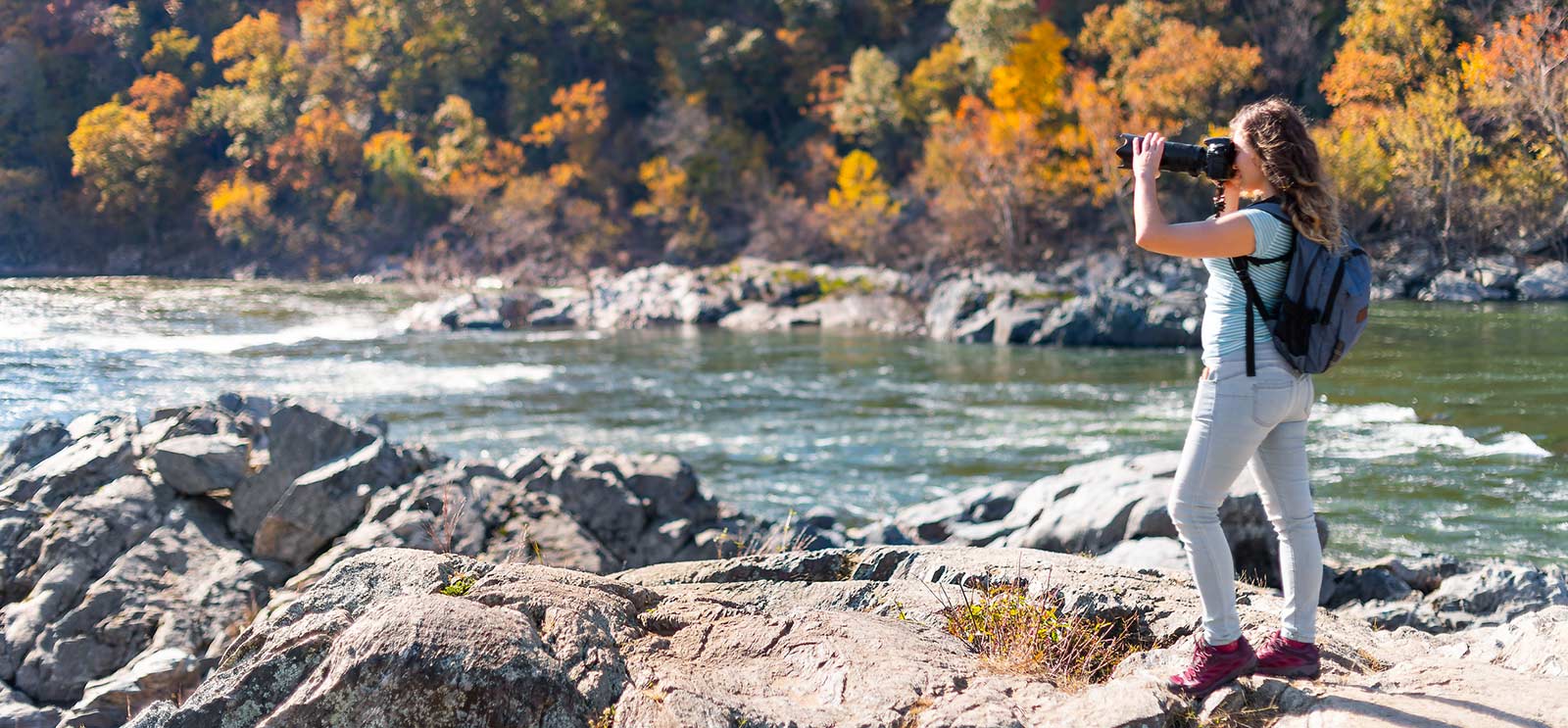 Young woman taking pictures at lake